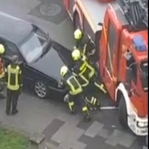 Feuerwehr schiebt Auto zur Seite.