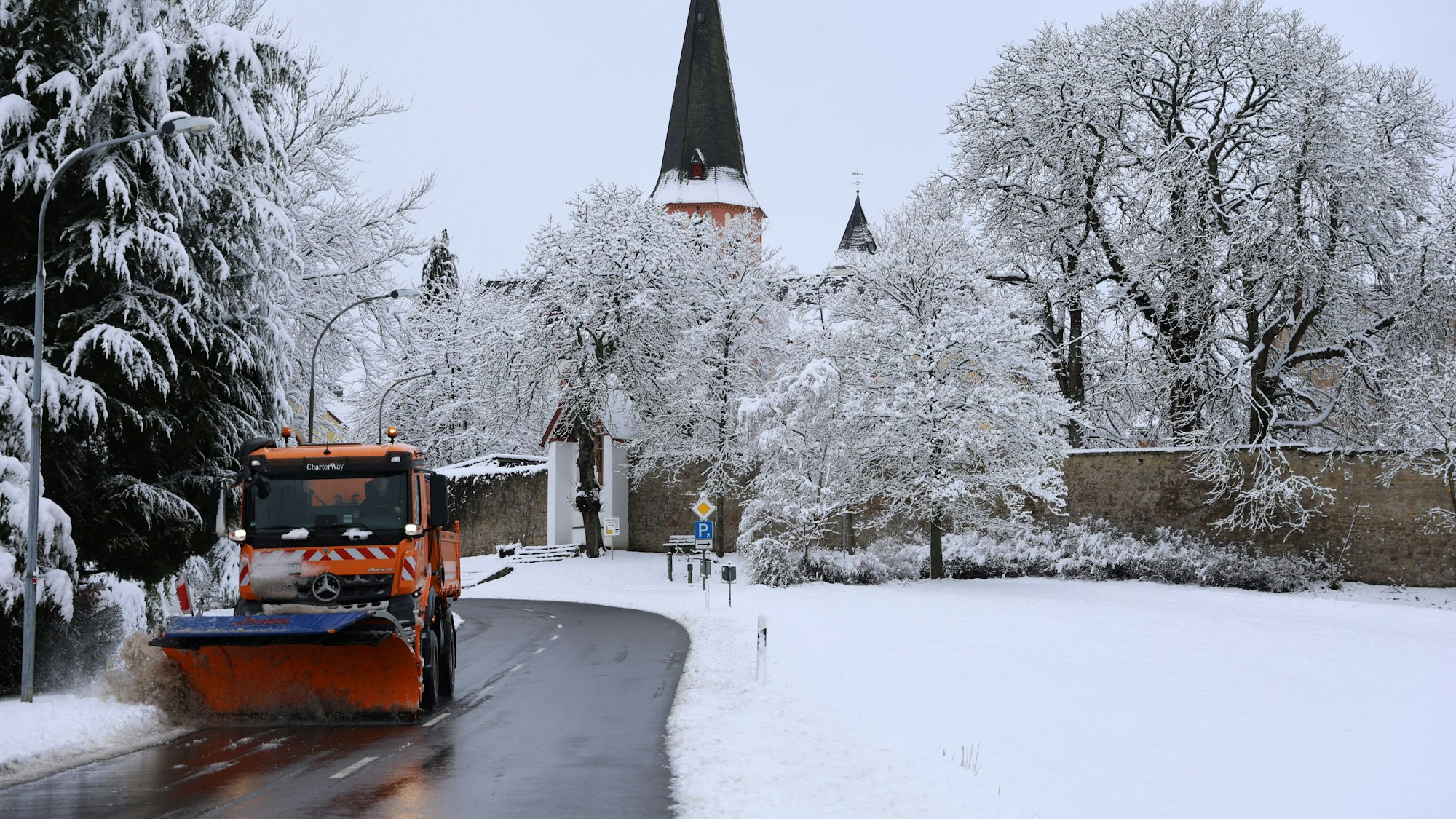 Das Kloster Steinfeld im Schnee. Ein Sträufahrzeug räumt Schnee von der Straße.
