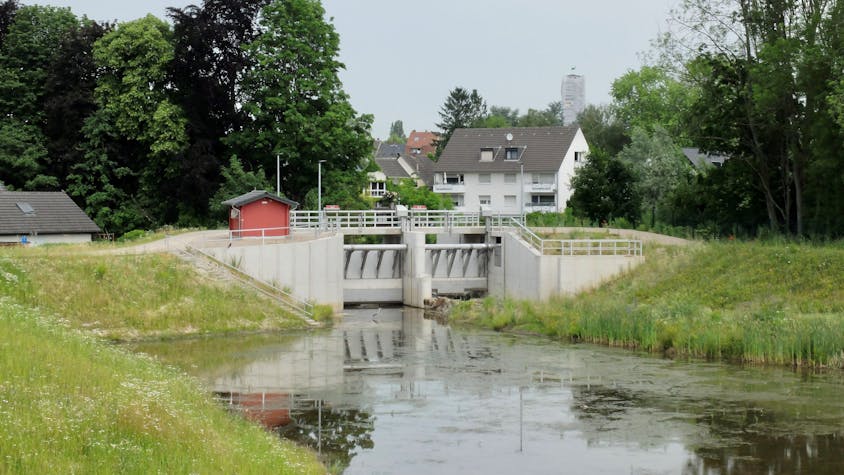 Hinter dem Hochwasserbecken und Schleuse Kippemühle in Bergisch Gladbach-Gronau liegen Häuser.&nbsp;