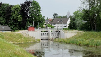 Hinter dem Hochwasserbecken und Schleuse Kippemühle in Bergisch Gladbach-Gronau liegen Häuser.