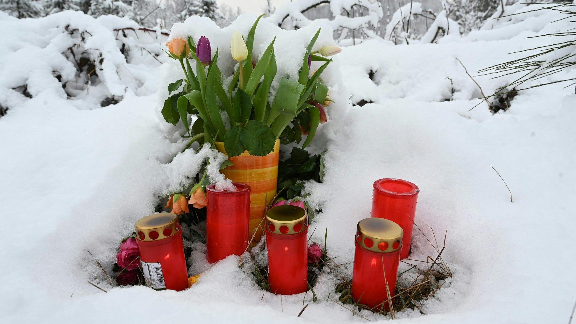 Am Fundort des ermordeten zwölfjährigen Mädchens Luise stehen Blumen und Kerzen. Frisch gefallener Schnee bedeckt den Boden.