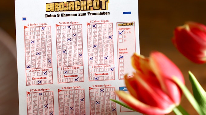 Eurojackpot Spielschein mit einer Tulpe im Vordergrund.