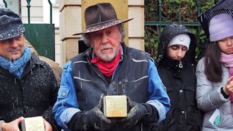 Künstler Gunter Demnig mit einem Stolperstein in der Hand