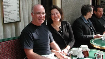 Gabriel Gorodetsky und Ruth Herz sitzen in einem Café in Paris und lächeln.
