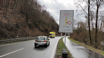 Blick auf die Verbindungsstrecke. Zwei Autos fahren auf der Straße. Ein Schild zeigt, dass die Strecke Höngesberg gesperrt ist.