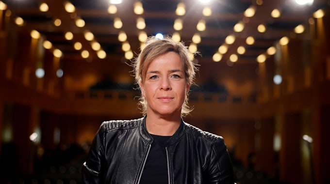 Mona Neubaur (Grüne), Ministerin für Wirtschaft, Industrie, Klimaschutz und Energie des Landes Nordrhein-Westfalen, ist bei einem Empfang zu sehen, hinter ihr sind viele Lichtpunkte an der Decke zu sehen.