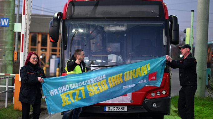 Streikende Mitarbeiter der Rheinbahn stehen am 9. Februar 2023 auf dem Betriebshof in Düsseldorf-Lierenfeld vor einem Bus.