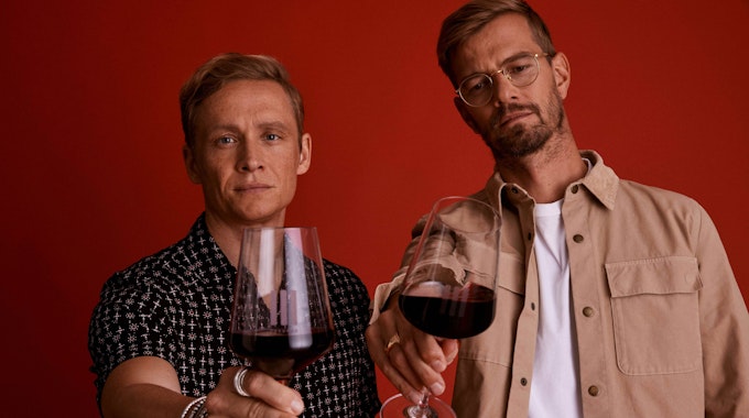 Schauspieler Matthias Schweighöfer und Moderator Joko Winterscheidt mit Weingläsern. In beiden ist Rotwein.