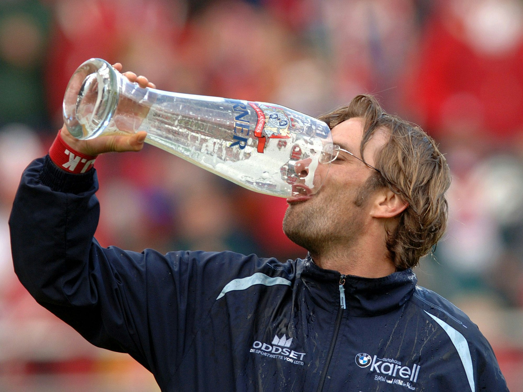Der Mainzer Trainer Jürgen Klopp leert ein Riesenglas Bier aus Freude über den geglückten Klassenerhalt seines Teams.