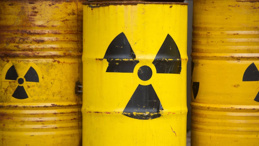 Drei gelbe Container, auf denen das Atomsymbol abgebildet ist.