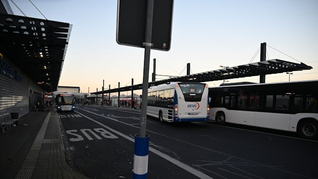 Auf dem Foto ist ein Busbahnhof mit mehreren REVG-Bussen zu sehen.