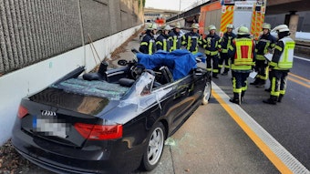 Mehrere Einsatzkräfte stehen vor einem Wagen, an dem sie das Dach hatten entfernen müssen, um eine Person zu befreien.