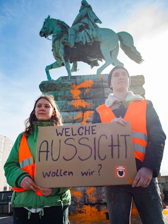 Zwei Aktivisten stehen vor dem Reiterdenkmal.Thomas Banneyer