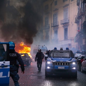Vermummte Hooligans haben vor dem Spiel auf einer Straße ein Polizeiauto in Brand gesetzt.