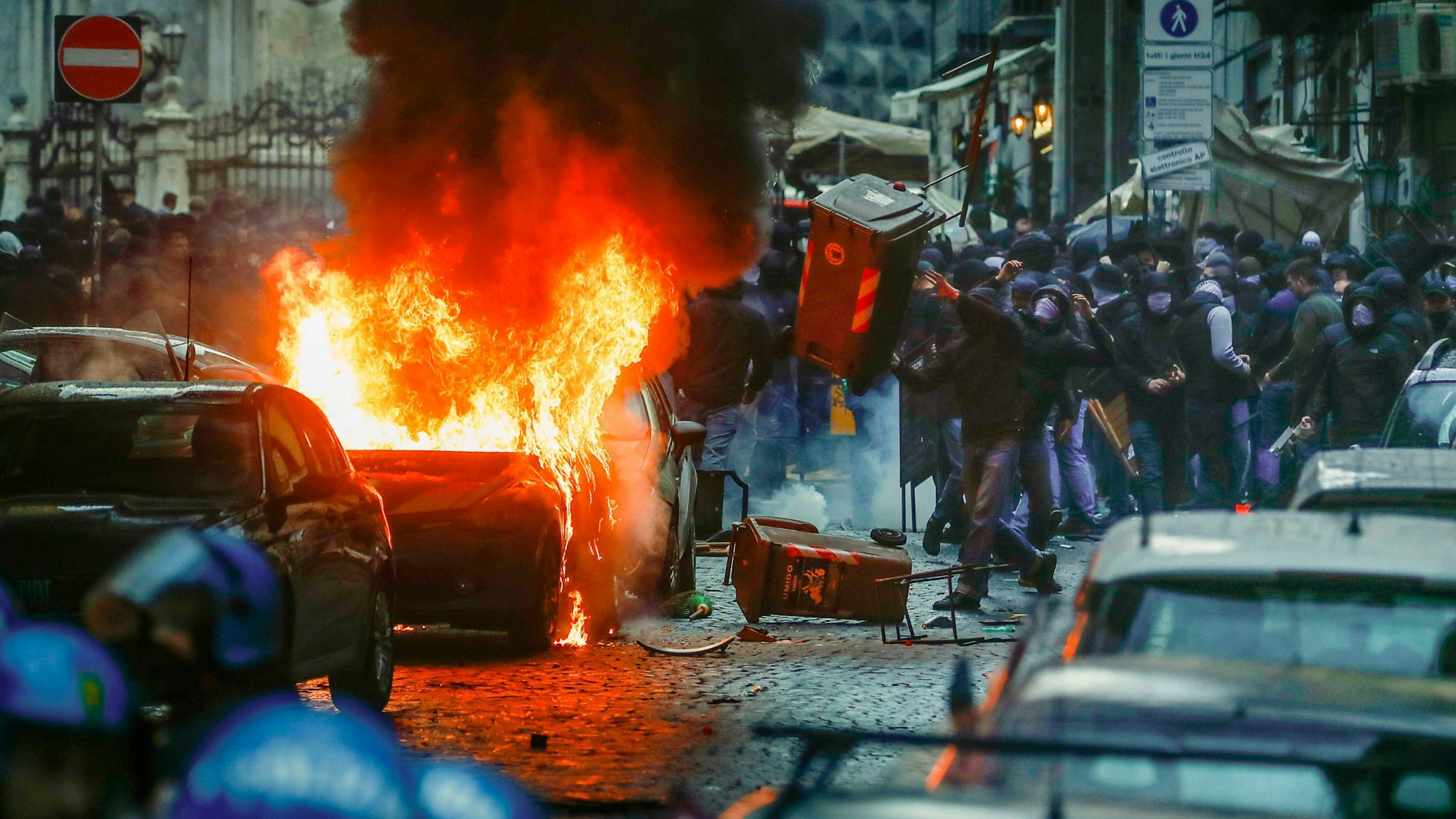 Vermummte Hooligans randalieren vor dem Spiel auf einer Straße in Neapel.