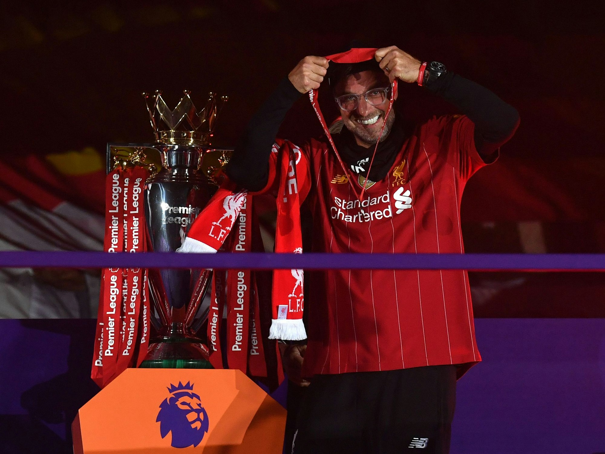 Liverpools deutscher Trainer Jürgen Klopp steht bei der Meisterehrung neben dem Premier-League-Pokal und hängt sich seine Medaille um.