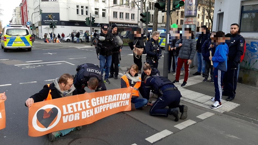 Polizei löst Klimakleber in Köln von der Straße.