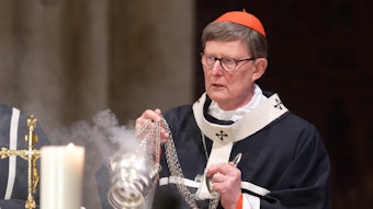 Kardinal Rainer Maria Woelki schwenkt ein Weihrauchfass.