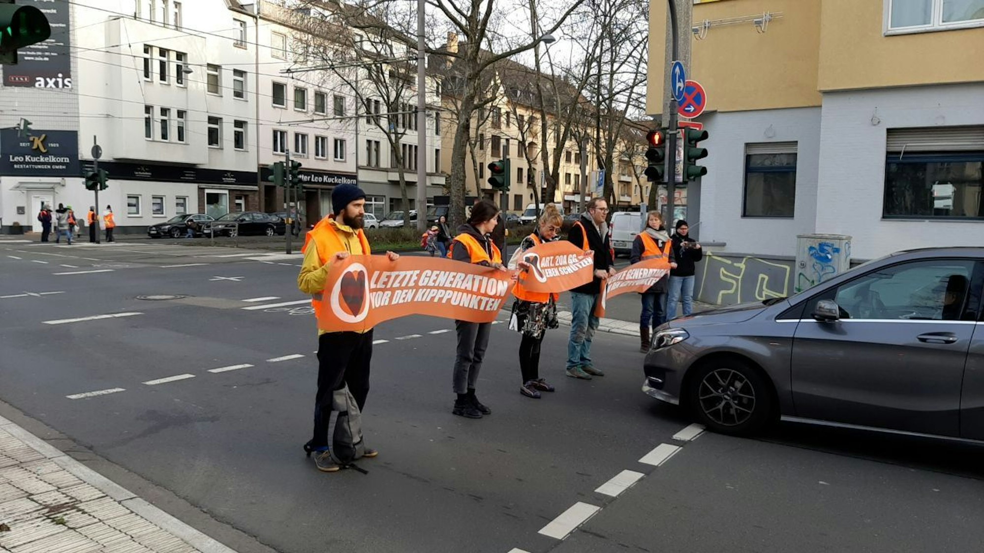 Aktivisten und Aktivistinnen der Letzten Generation blockieren am Freitagmorgen die Hauptverkehrsader Sülzgürtel/ Luxemburger Straße in Köln.