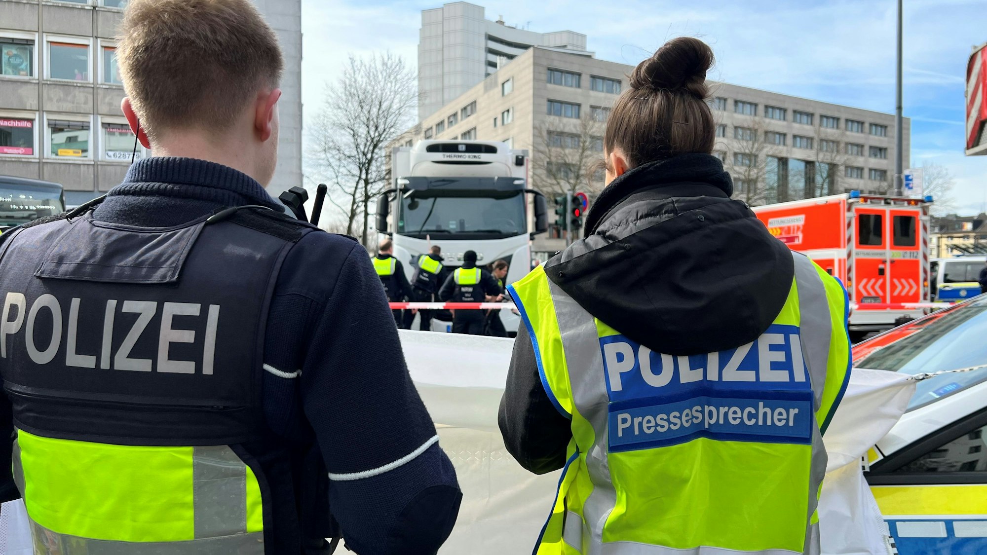 Einsatzkräfte der Polizei stehen am Wiener Platz.