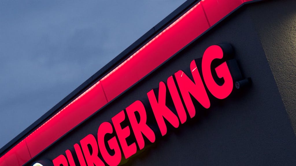 Eine Fassade einer Burger-King-Filiale, auf der Logo und Schriftzug des Fast-Food-Restaurants angebracht sind.
