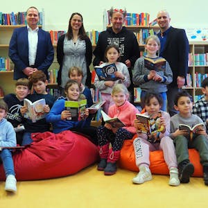 Grundschüler der Rosenzweiggrundschule in Zollstock sitzen auf bunten Sitzsäcken und halten Bücher in der Hand.&nbsp;