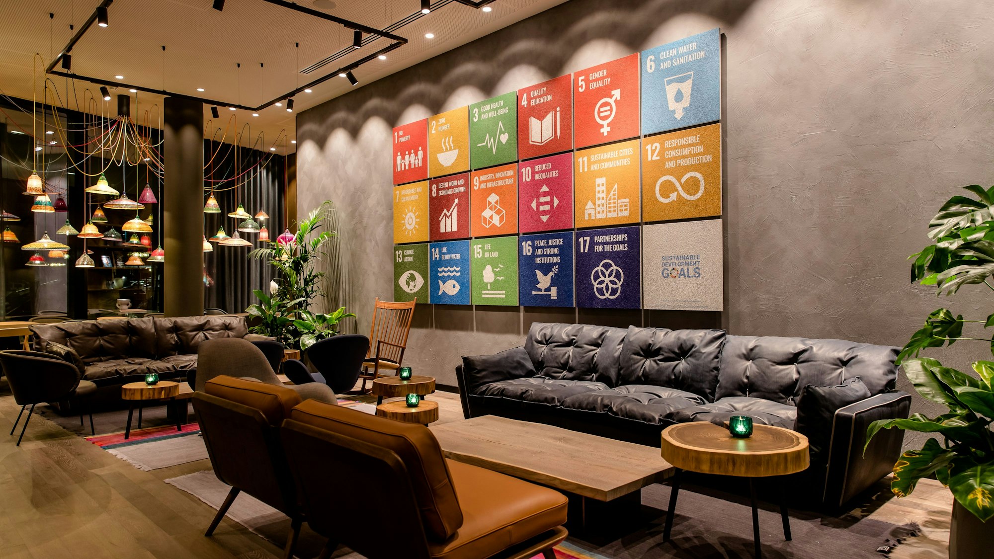 Motel One in Bonn, ander Wand hängt eine Tafel mit den 17 Nachhaltigkeitszielen der UN