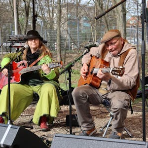 Zwei Personen spielen Gitarre auf einer provisorischen Bühne.