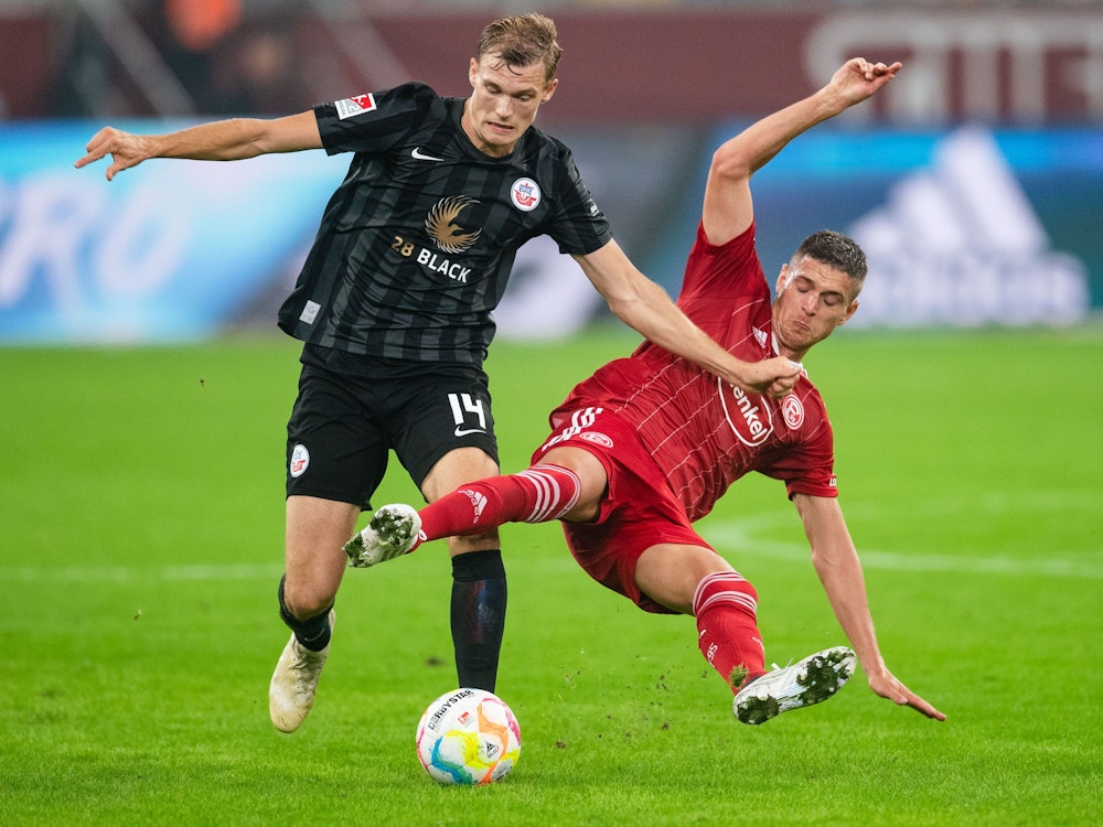 Düsseldorfs Kristoffer Petersen und Rostocks Svante Ingelsson kämpfen um den Ball.