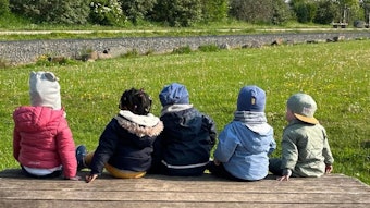 Das Bild zeigt mehrere Kinder in einem Garten.