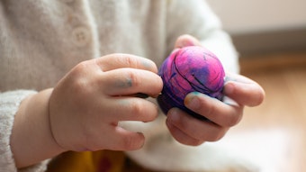 Ein Kleinkind hält einen Ball.