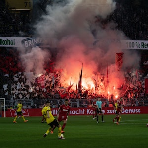 Im Kölner Fanblock in Dortmund brennt am 18. März 2023 Pyrotechnik.