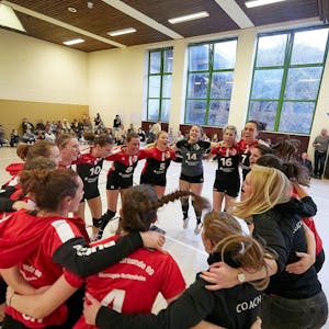 Die Volleyballerinnen aus Marmagen und ihre Trainerinnen bilden einen Kreis und jubeln über den Aufstieg.