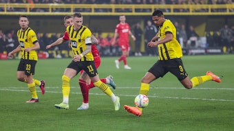 Drei Spieler von Dortmund laufen mit dem Ball nach vorne, sodass der Kölner Spieler nicht an den Ball kommt.
