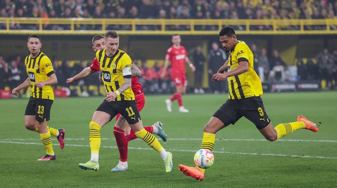 Drei Spieler von Dortmund laufen mit dem Ball nach vorne, sodass der Kölner Spieler nicht an den Ball kommt.