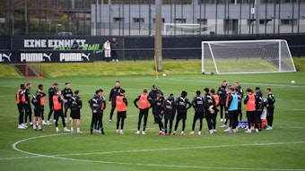 Die Mannschaft von Borussia Mönchengladbach am 14. März 2023 beim Training im Borussia-Park. Das Team steht in einem Kreis zusammen auf dem Rasen.