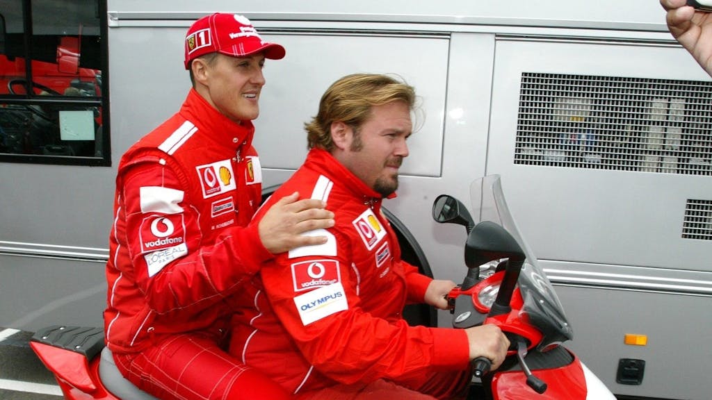 Michael Schumacher und Gino Rosato fahren auf einem Motorroller.
