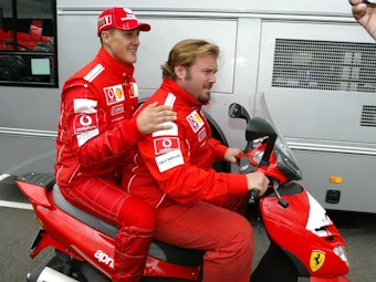 Michael Schumacher und Gino Rosato fahren auf einem Motorroller.