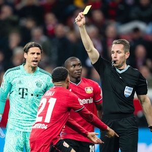 Schiedsrichter Tobias Stieler (r) zeigt Leverkusens Amine Adli (M) die Gelbe Karte, die er später zurücknimmt.