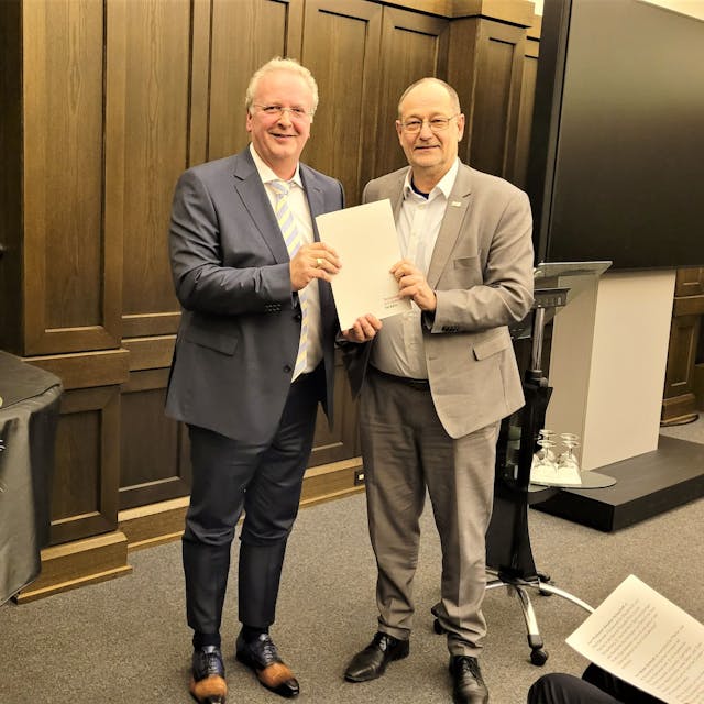 Prof. Dr. Stefan Herzig, Präsident der TH Köln, übergibt Uwe Ufer eine Urkunde.

