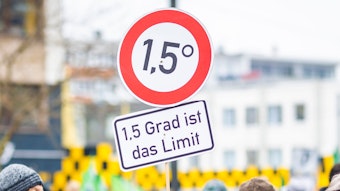 Der Schriftzug „1,5 Grad ist das Limit“ ist auf einem Protestplakat in der Optik eines Verkehrsschildes bei einer Kundgebung von Fridays for Future zu lesen.