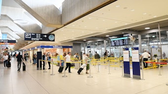 Menschen gehen am Flughafen Köln/Bonn durch die Sicherheits-Gates zu ihren Flügen.