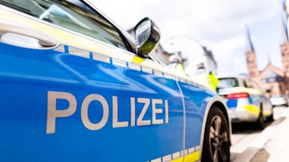 Zwei Einsatzfahrzeuge der Polizei stehen in Freiburg am Straßenrand. (Symbolbild)