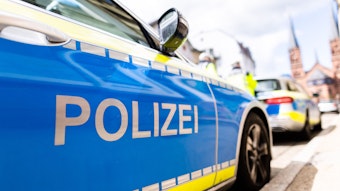 Zwei Einsatzfahrzeuge der Polizei stehen in Freiburg am Straßenrand