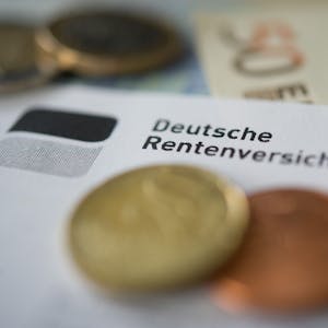 Auf einem Papier mit der Aufschrift Deutsche Rentenversicherung liegen Cent-Stücke.