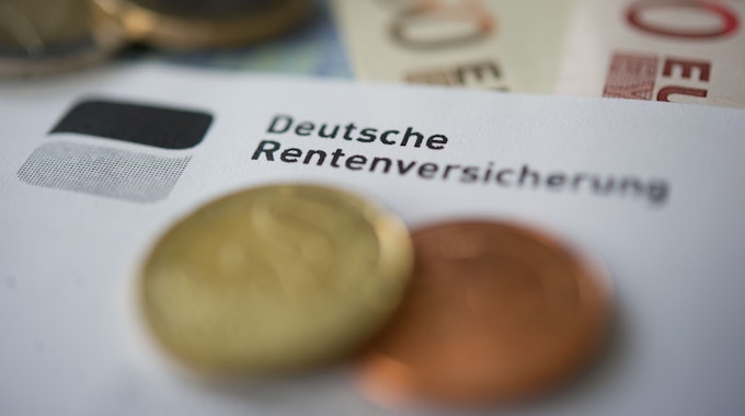 Auf einem Papier mit der Aufschrift Deutsche Rentenversicherung liegen Cent-Stücke.