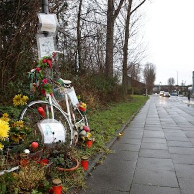 Ein weißes Fahrrad, Blumen und Kerzen am Rand des Radwegs entlang des Auenwegs in Köln-Mülheim erinnern an die verstorbene Miriam Scheidel