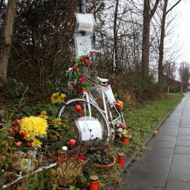 Ein weißes Fahrrad, Blumen und Kerzen am Rand des Radwegs entlang des Auenwegs in Köln-Mülheim erinnern an die verstorbene Miriam Scheidel