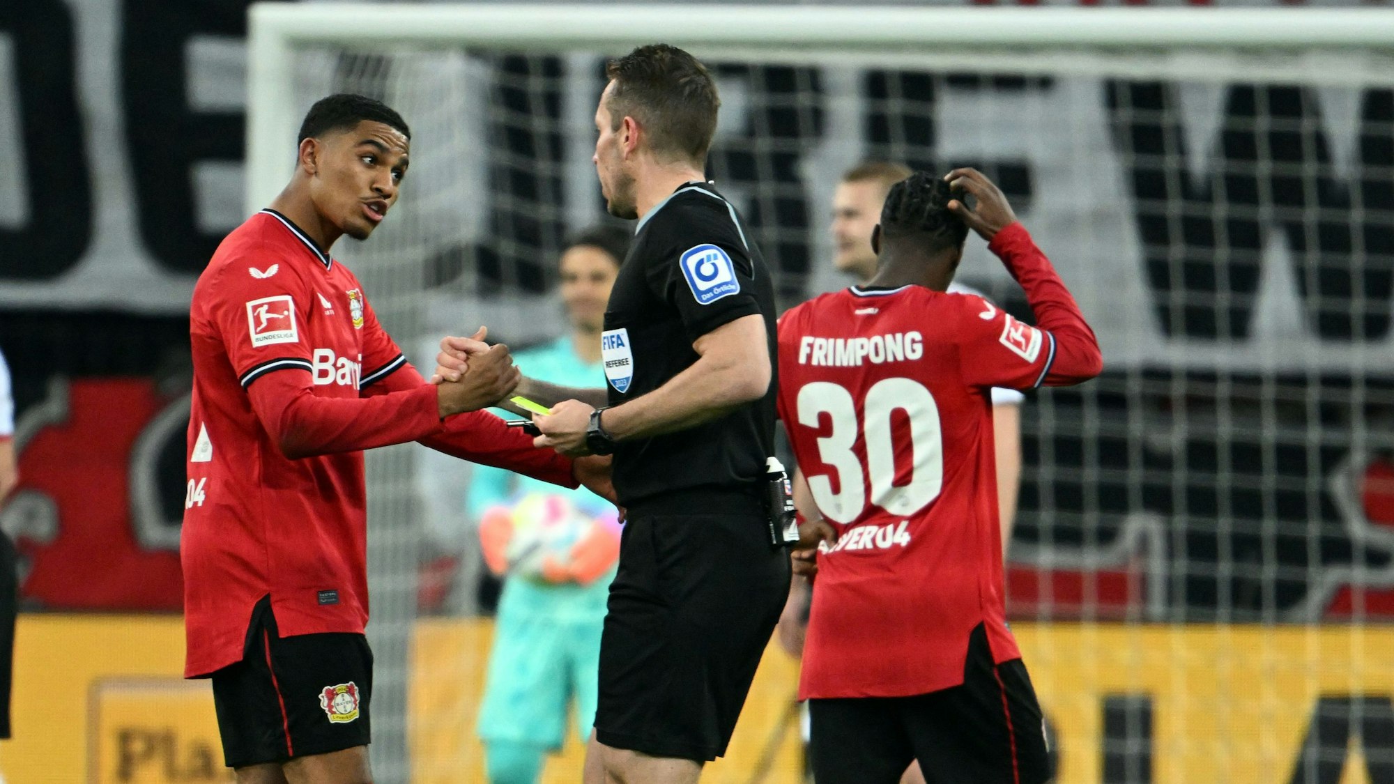 Schiedsrichter Tobias Stieler (r) spricht mit Leverkusens Amine Adli (l), nachdem er eine Gelbe Karte zurückgenommen hat und Elfmeter für Leverkusen entschieden hat.