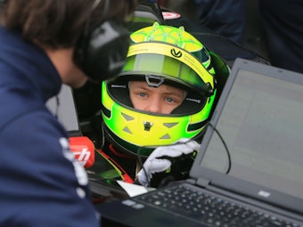 Der deutsche Rennfahrer Mick Schumacher vom niederländischen Team Van Amersfoort Racing sitzt in seinem Rennwagen und spricht mit einem Mitarbeiter seines Teams. 